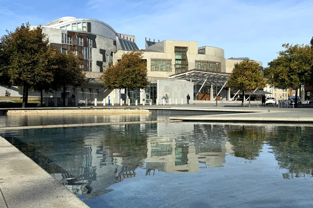 The Scottish Parliament building reflected in a still pool